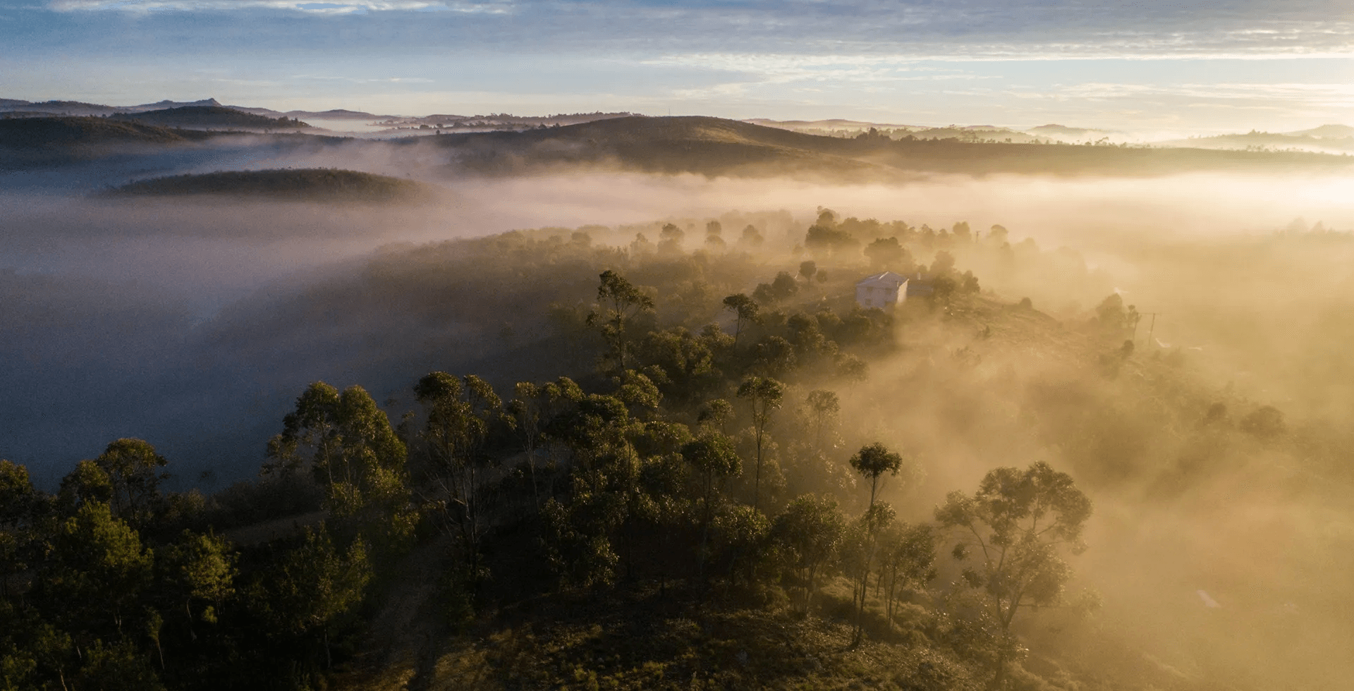 Paysage montagneux vu de drône avec une maison et légère brume