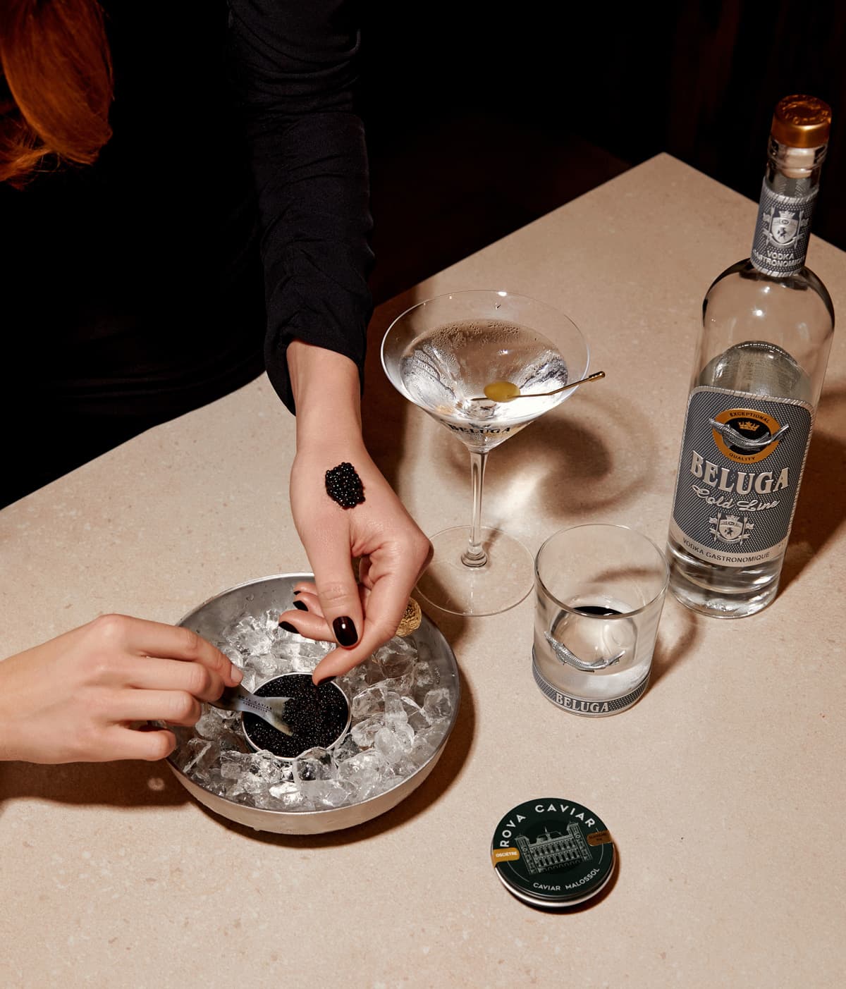 Caviar servi sur glace avec un martini et une bouteille de vodka Beluga