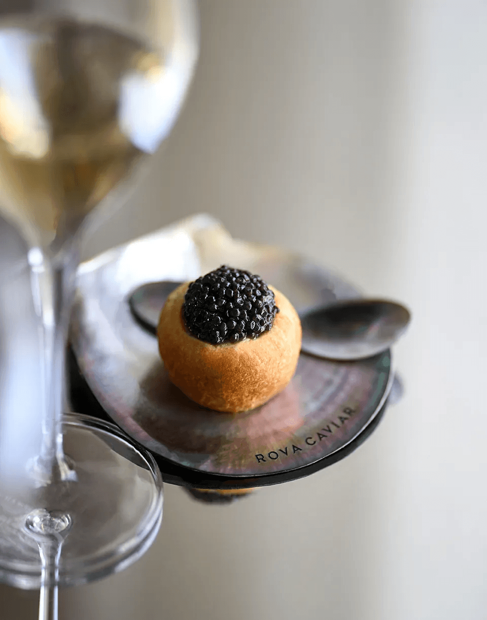 Bouchée garnie de caviar accompagnée d’un verre de vin blanc