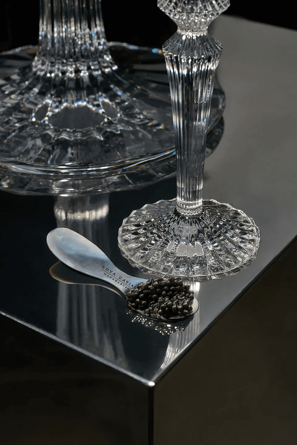 Cuillère en nacre garnie de caviar au pied d’un verre en cristal