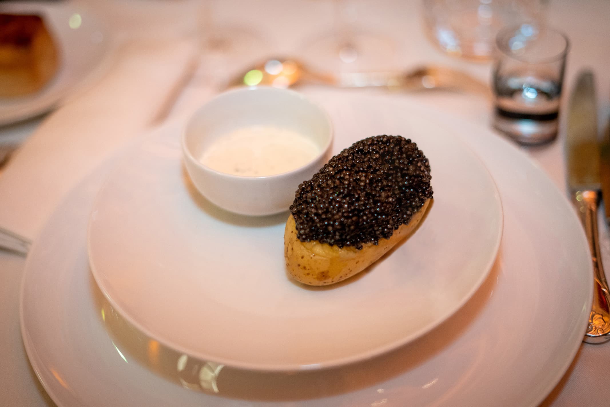 Pomme de terre garnie de caviar servie avec de la crème